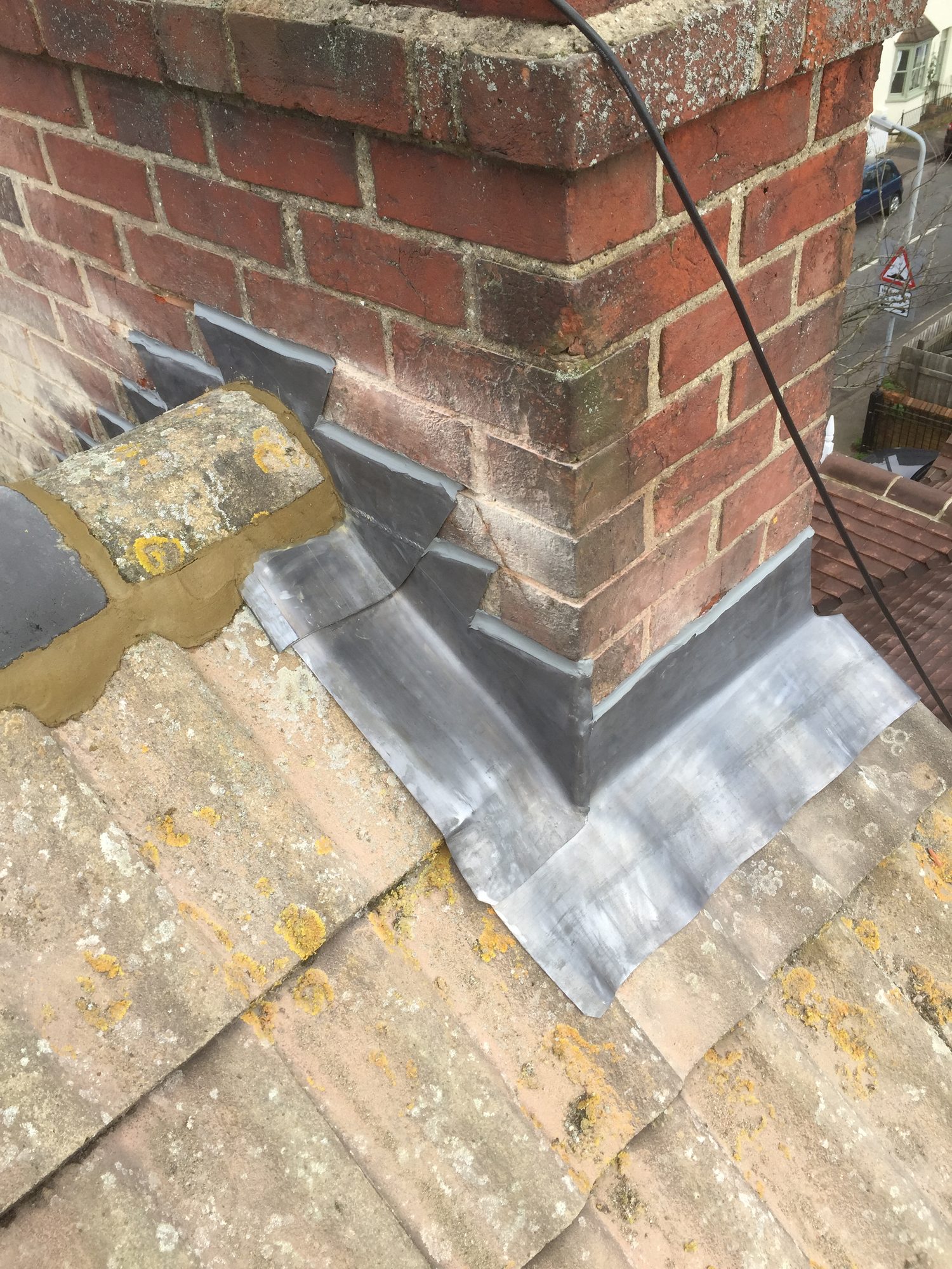 Completed - The completed lead flashing around the base of the brick chimney and surrounding roof tiles