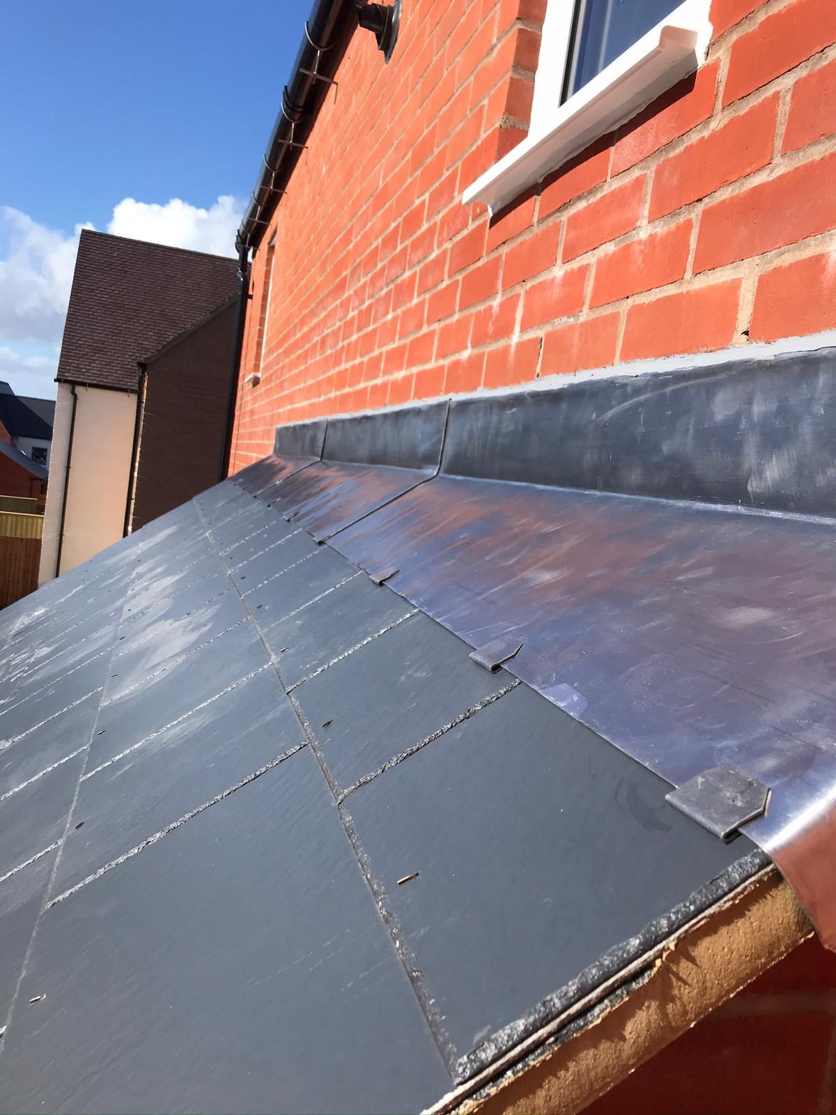 Completed - The completed slate roof showing new lead flashing neatly fitted along the adjoining brick wall