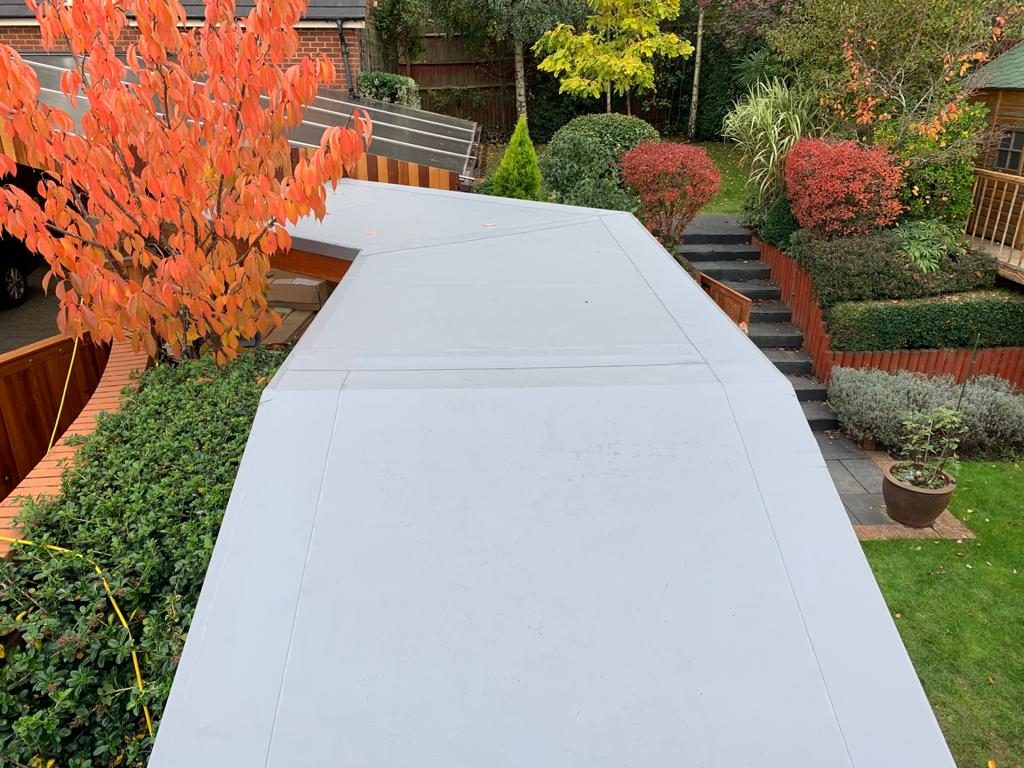 Completed - The completed single-ply flat roof viewed from above, showing the smooth finished membrane and neat detailing