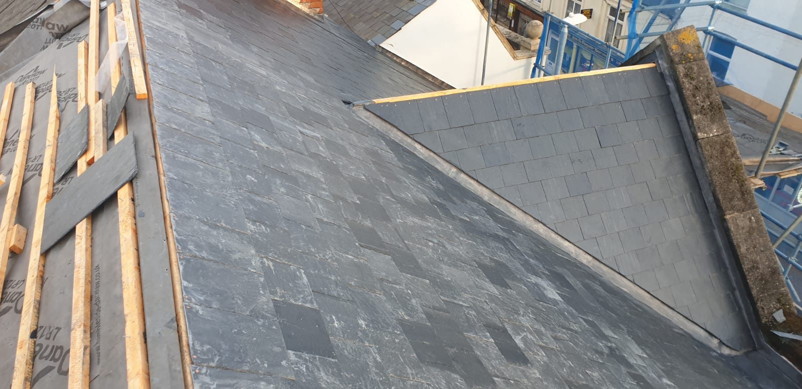 During - New slate roofing installed alongside exposed membrane and timber battens during the large slate roof replacement