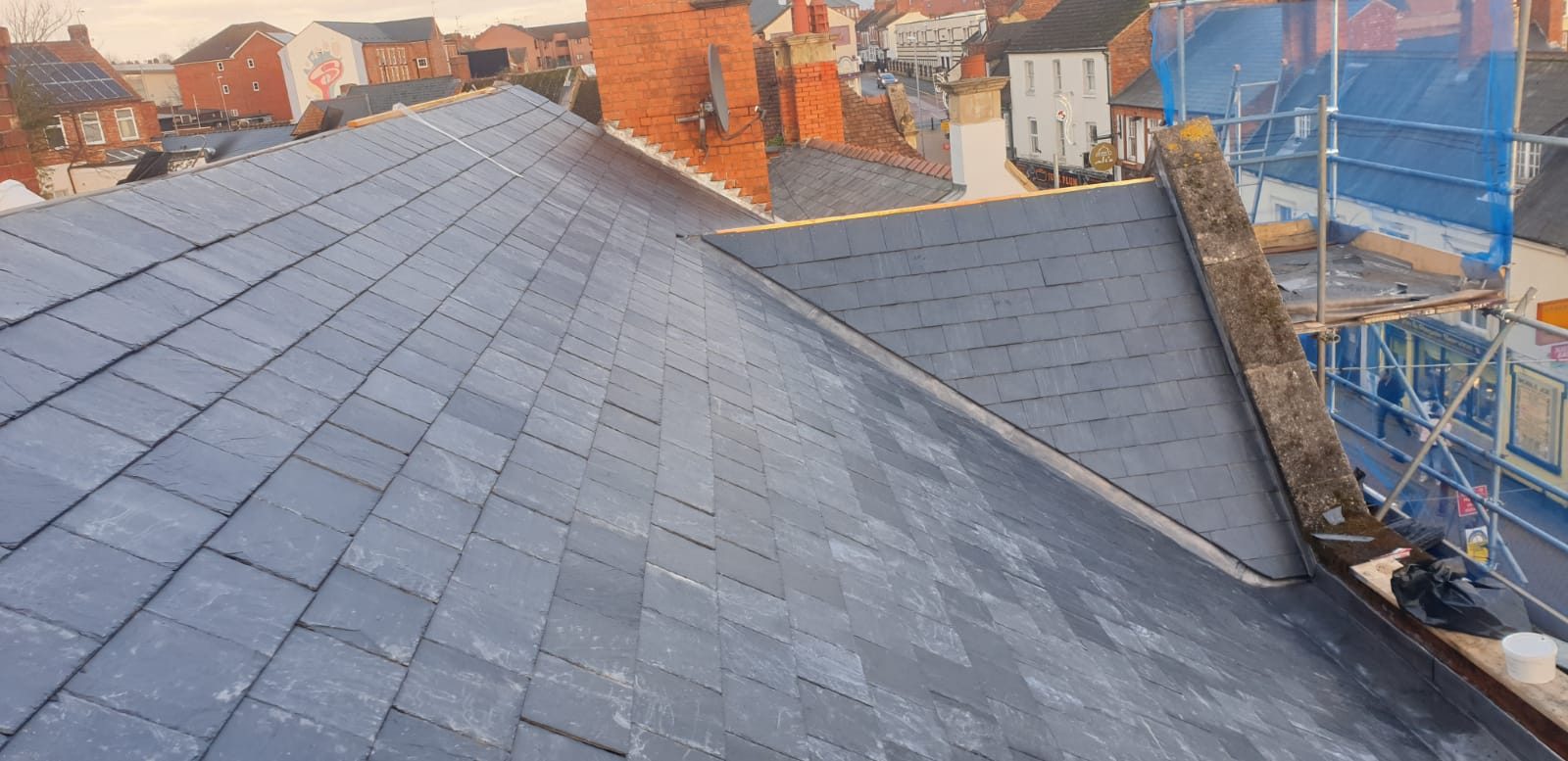 During - New slate roofing installed across the main roof and adjoining sections during the roof replacement