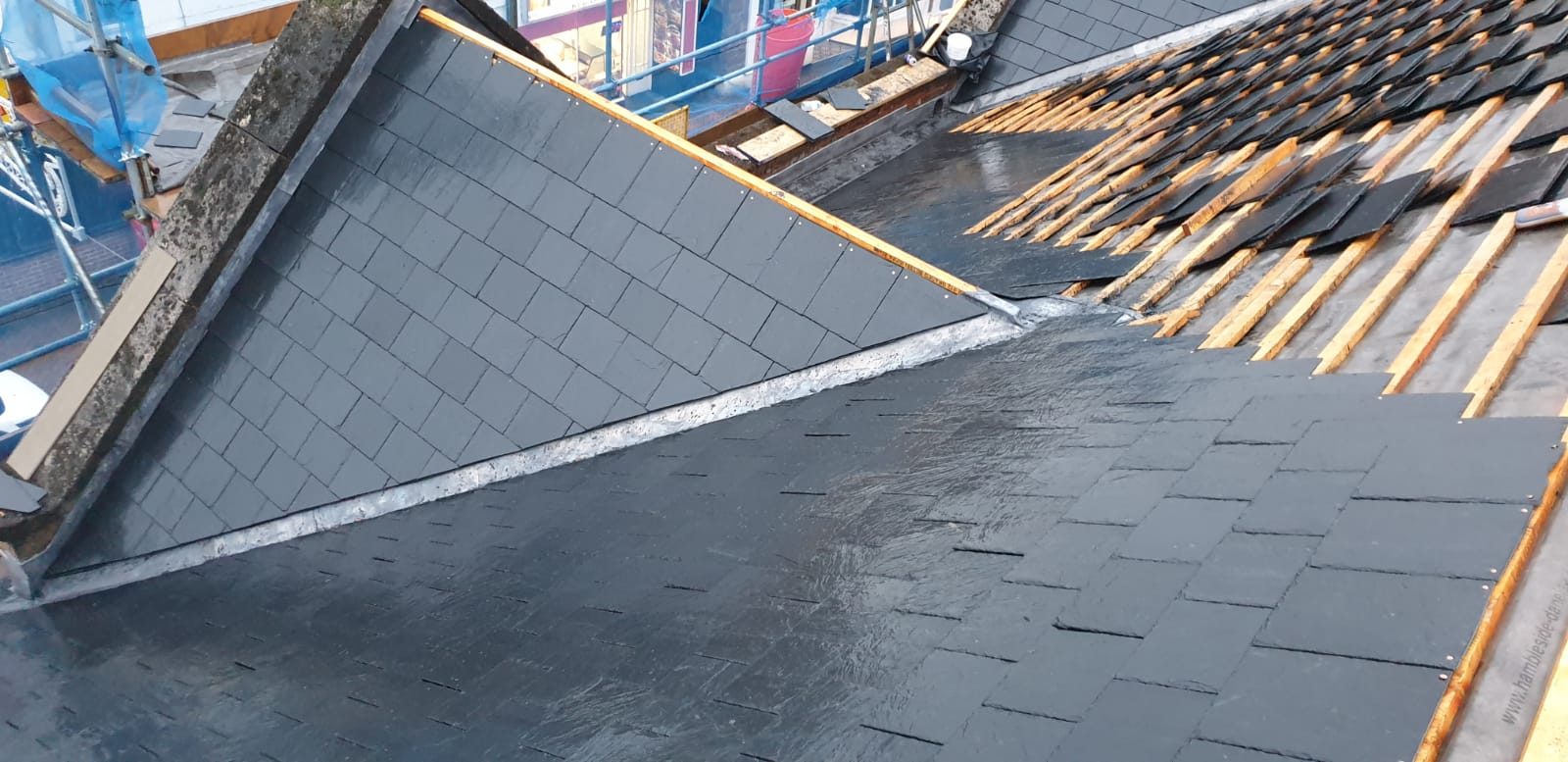 During - New slate roofing being installed over membrane and timber battens during the large roof replacement