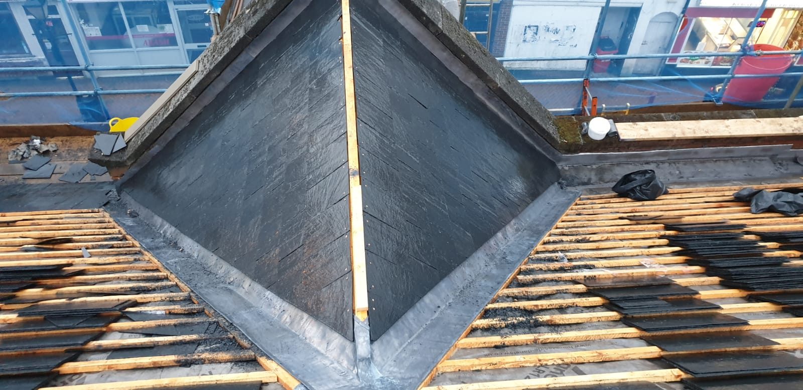 During - New slate roofing and leadwork installed around the raised roof section with battens exposed on the surrounding roof