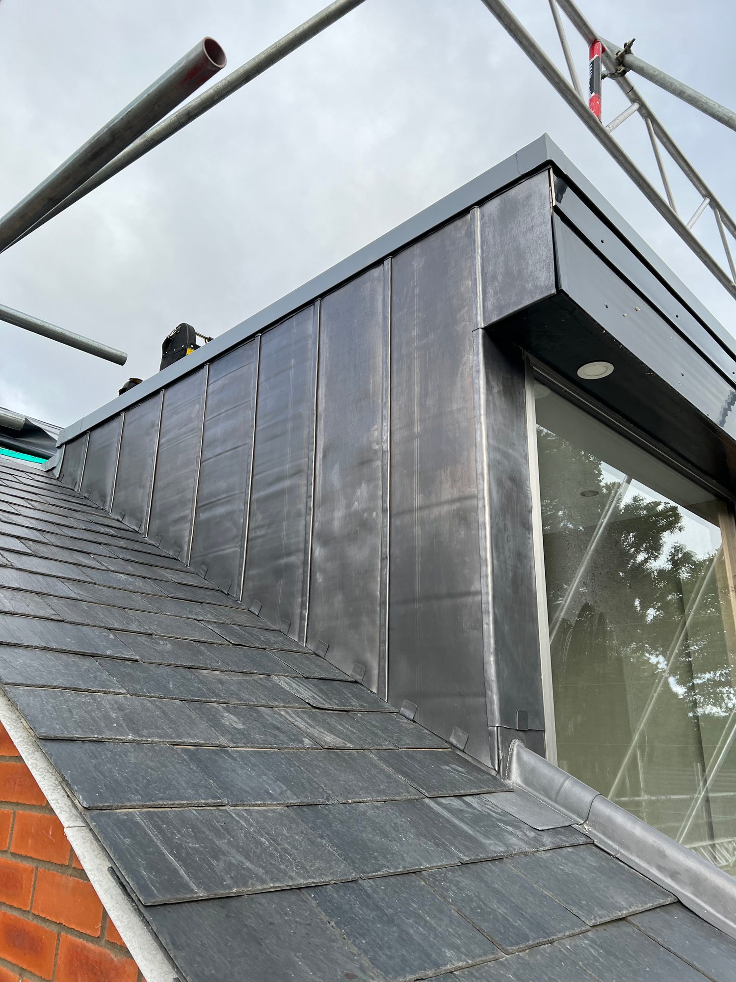 Completed -Completed slate roof with finished lead cladding and flashing around the raised roof structure