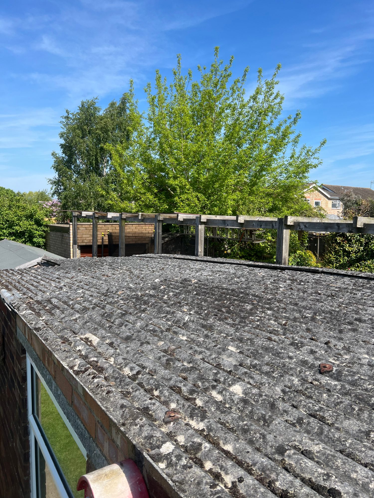 Before - The garage roof before refurbishment showing weathered corrugated roof sheets with visible staining, debris and surface deterioration