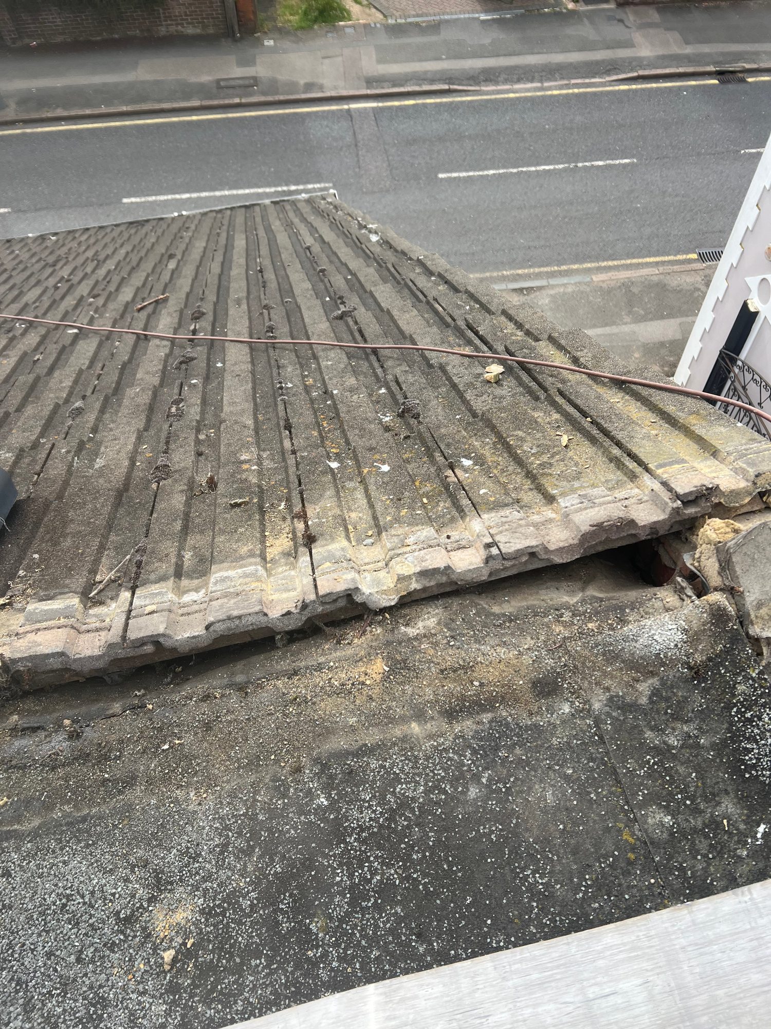 Before - The existing roof before refurbishment showing weathered tiles, debris and signs of deterioration across the roof surface