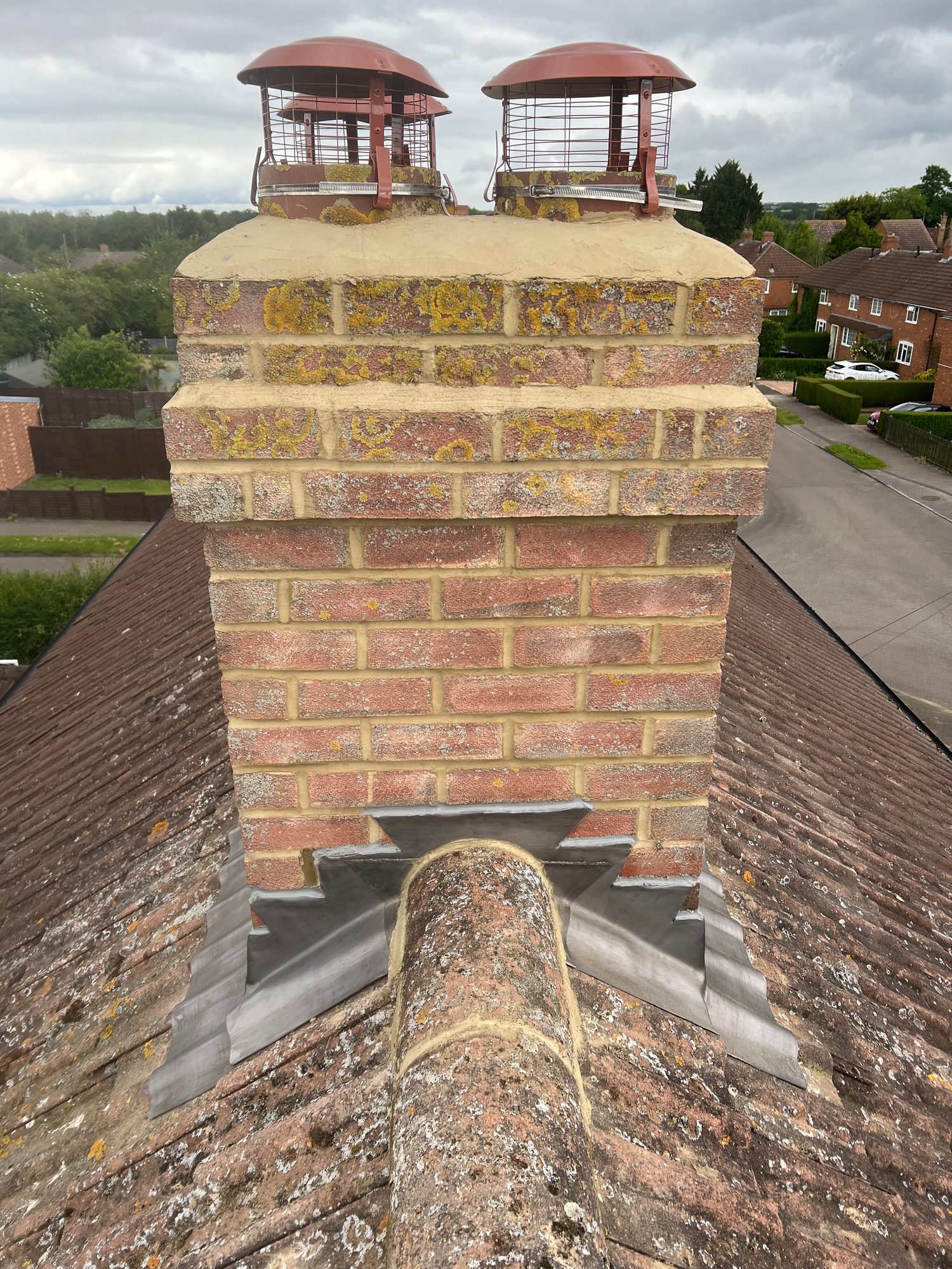 Completed - The completed chimney stack showing repointed brickwork, new lead flashing around the base and protective cowls fitted to the chimney pots