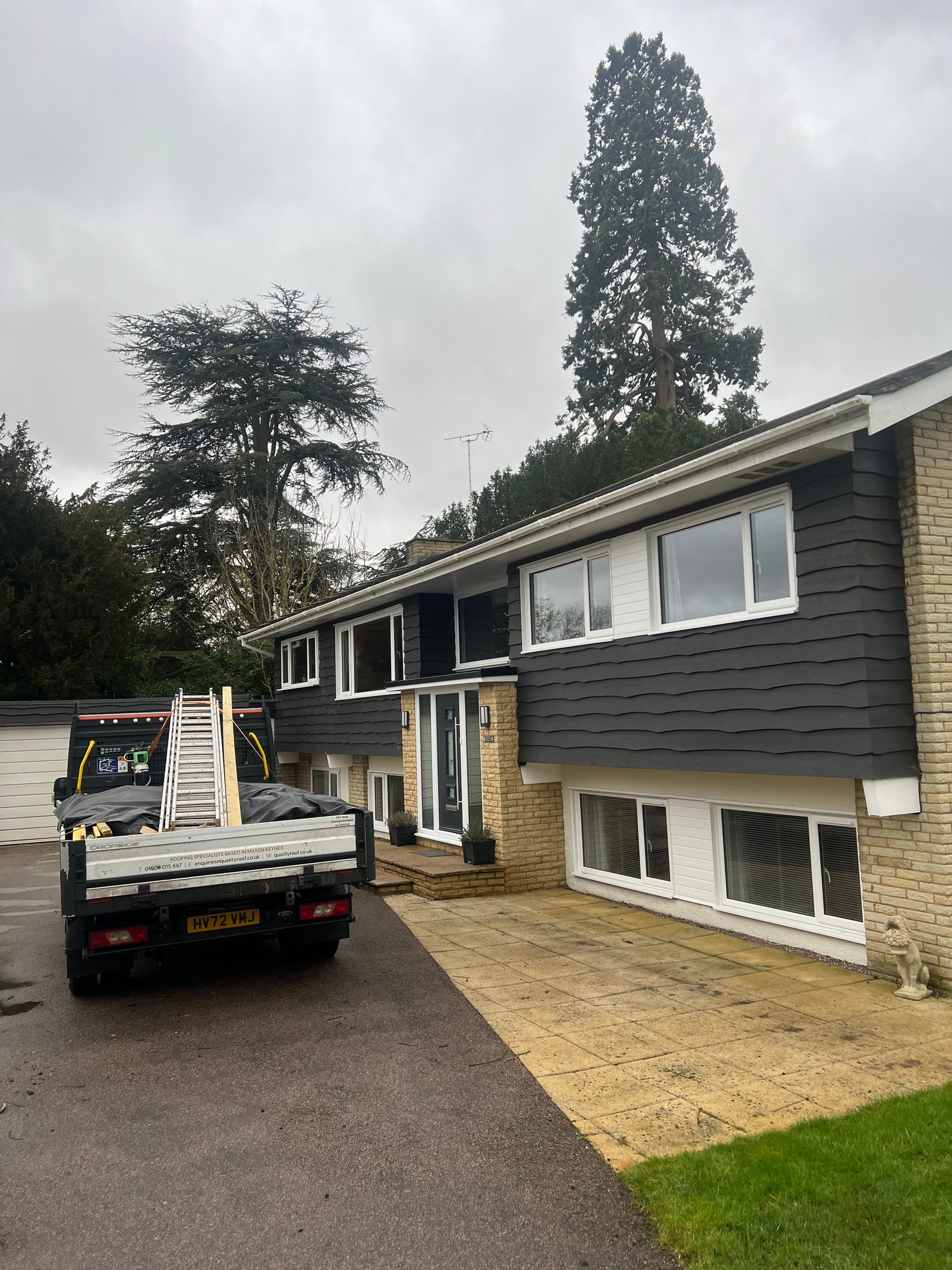 Before - The completed property showing the dark cladding, brickwork, windows, entrance, paving and driveway