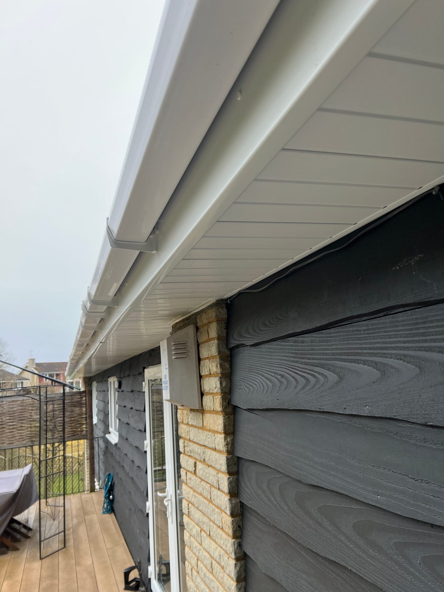 Completed - The completed white soffit, fascia and guttering alongside the dark exterior cladding and brickwork