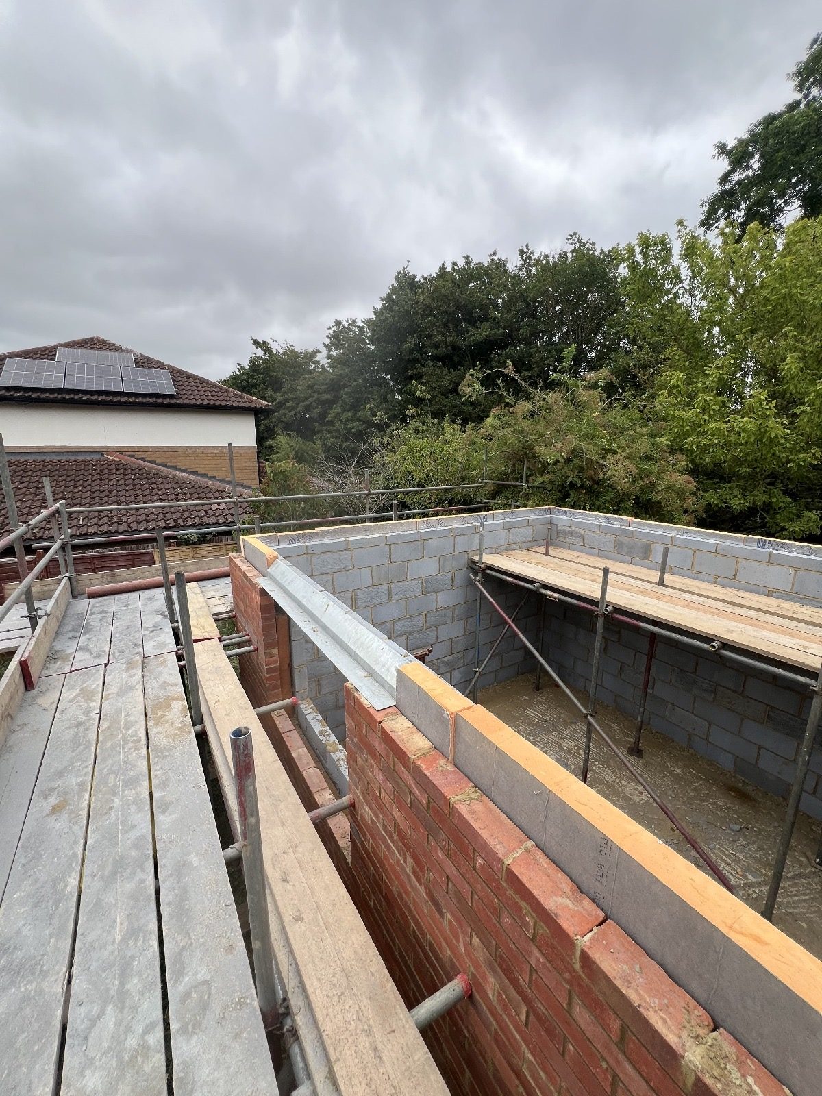 View from scaffolding showing blockwork walls, brickwork, timber access platforms
