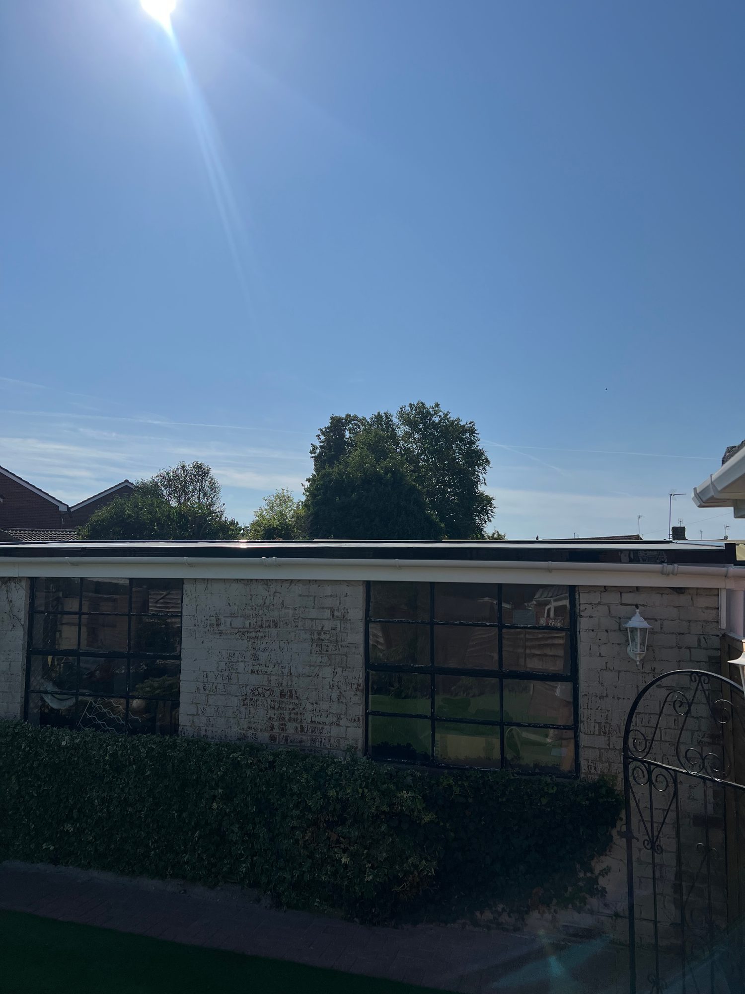 Completed single-storey flat roof with finished roof edging and guttering visible along the building frontage