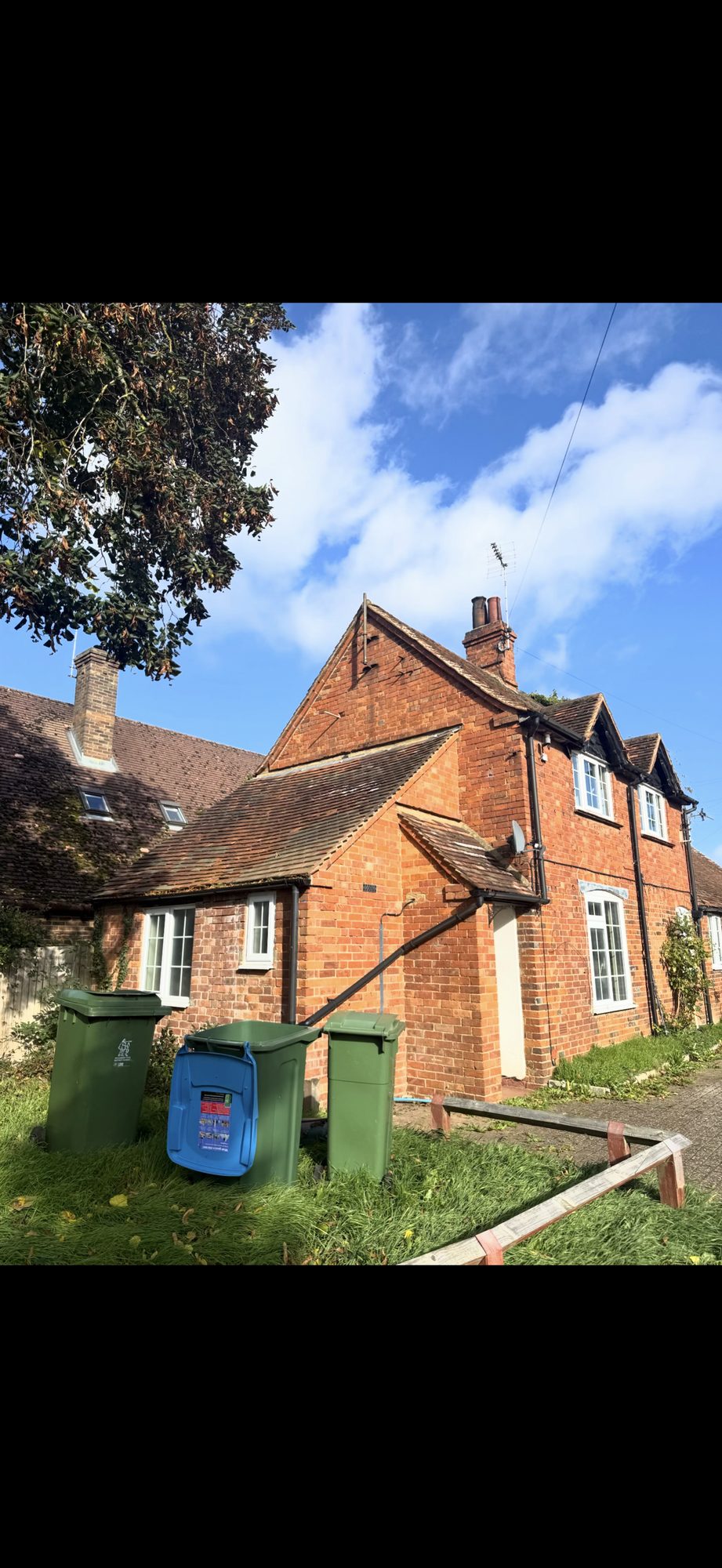 Period brick property with ageing tiled roofs across the main house and connected single-storey sections