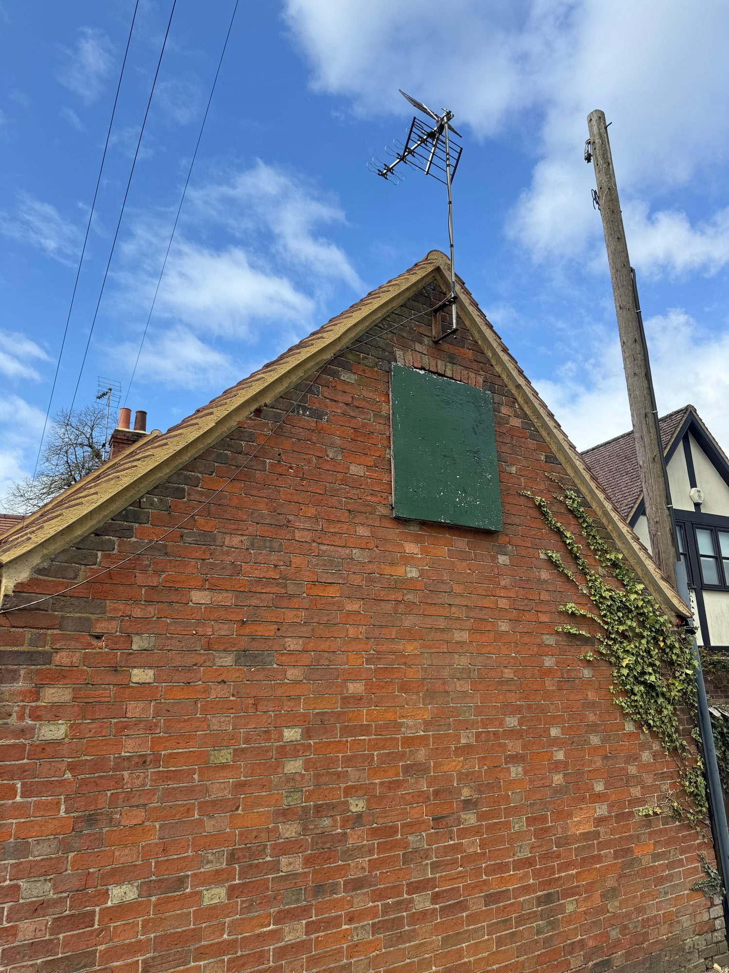 Brick gable with neatly finished mortar verges bordering the new roof tiles