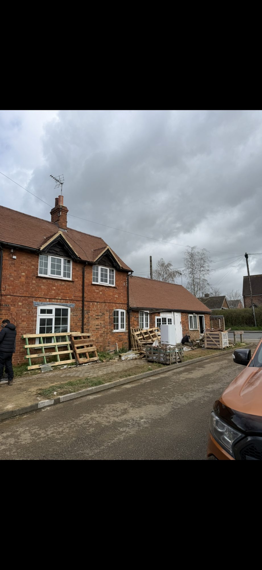 New roof tiles extending across the main brick house and adjoining single-storey building