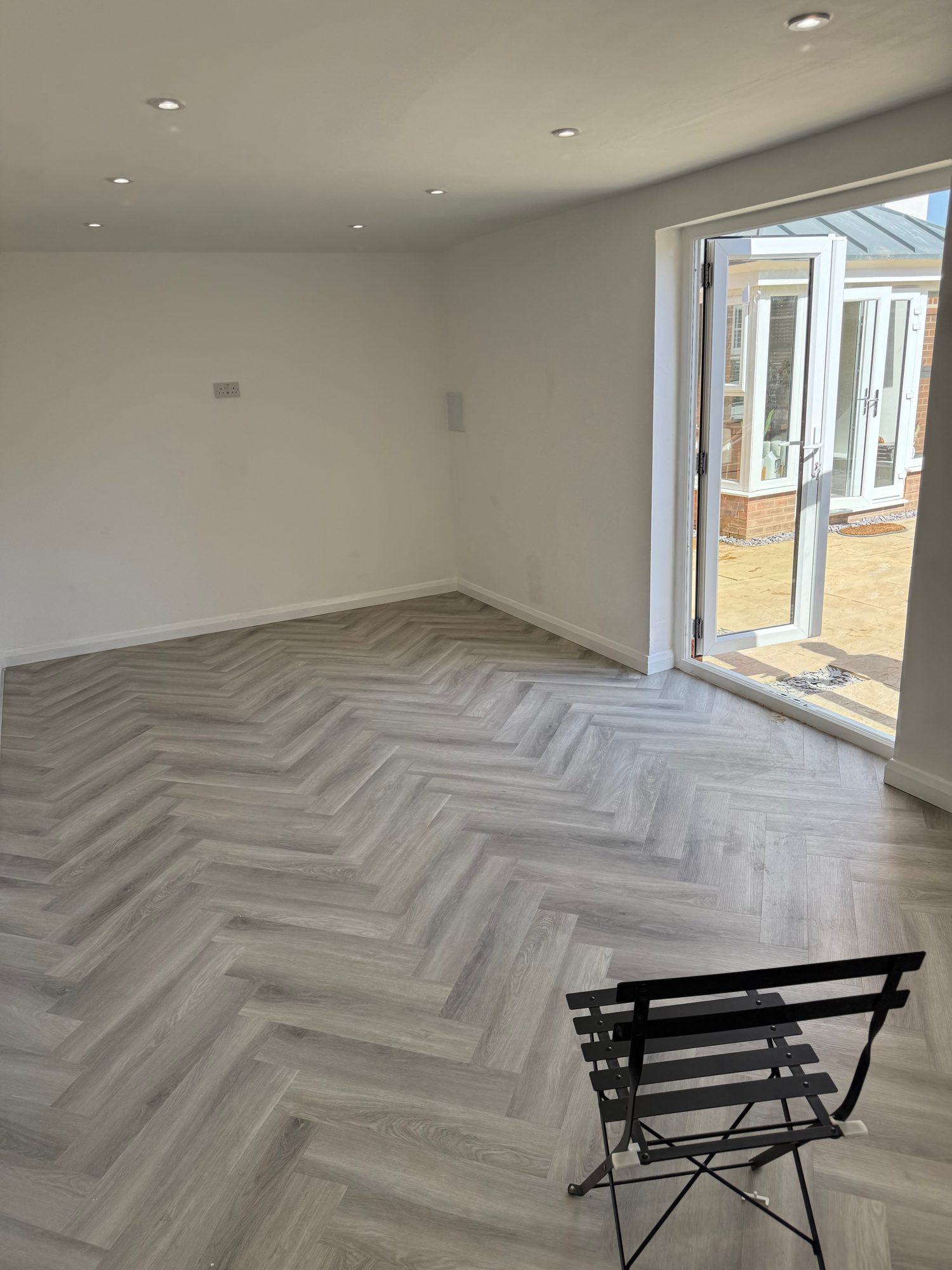 Bright converted room with open glazed double doors providing direct access to the outdoor area