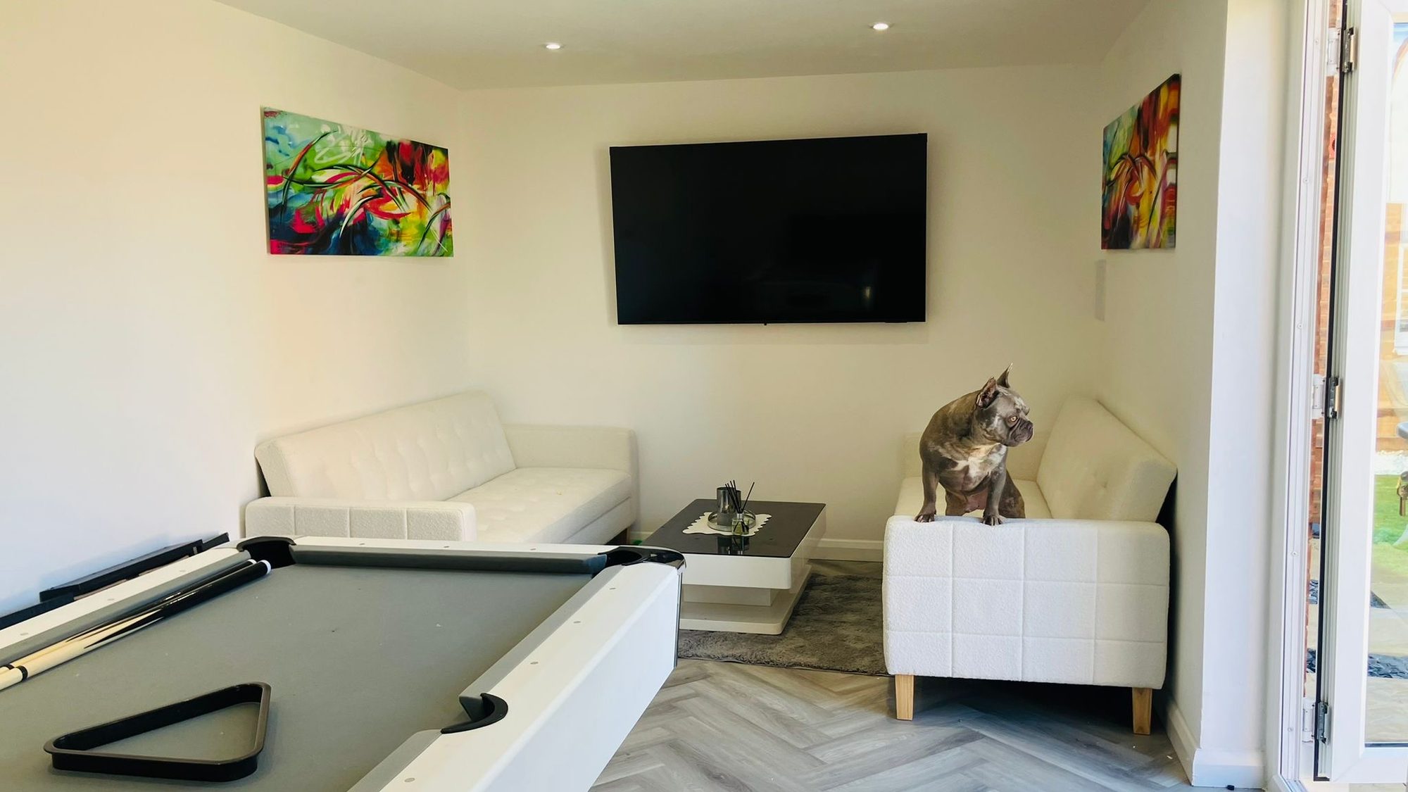 Furnished entertainment room with herringbone flooring, recessed lighting, a wall-mounted television and games table