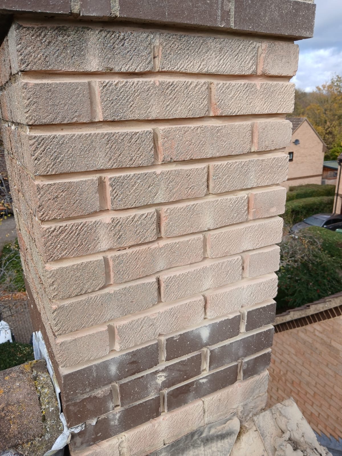Close-up of newly laid chimney brickwork with fresh mortar joints and exposed flashing at the base