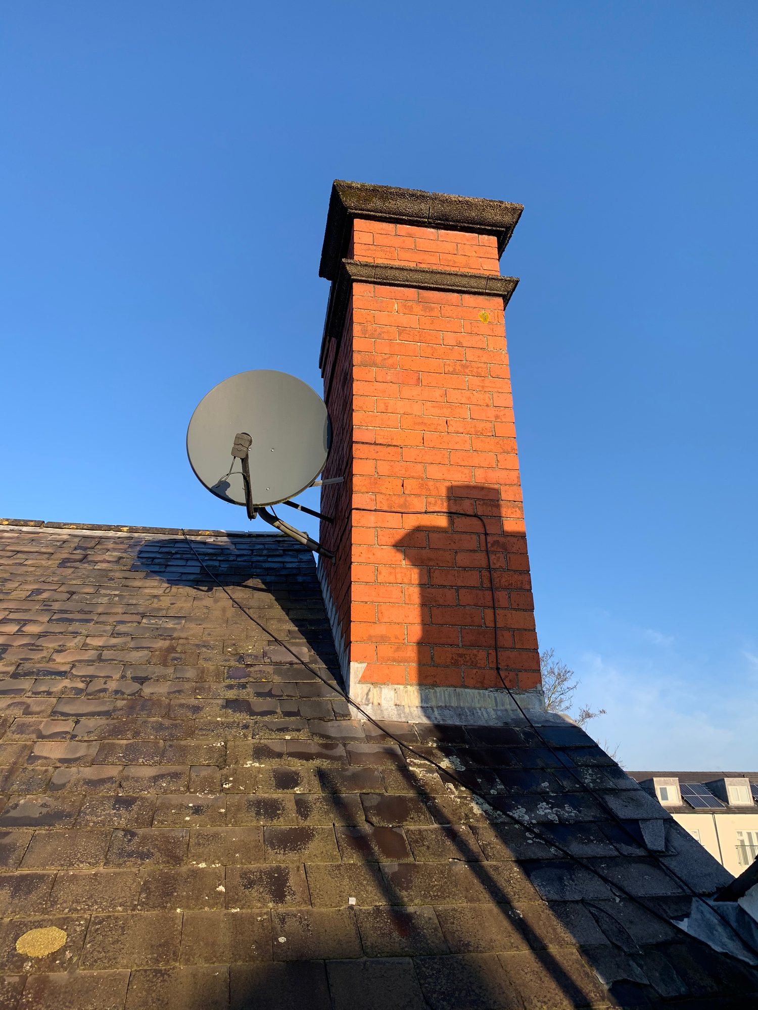 Before - The existing slate roof and brick chimney before replacement works began