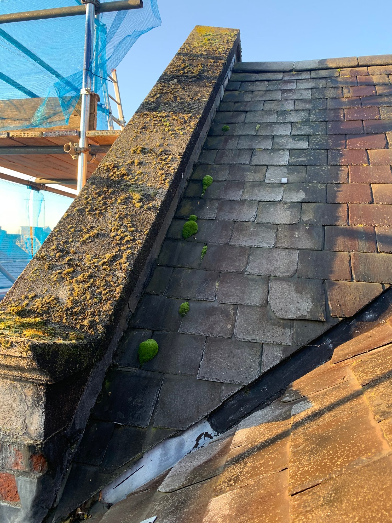 Before - The existing slate roof showing aged slates and areas of moss before replacement works