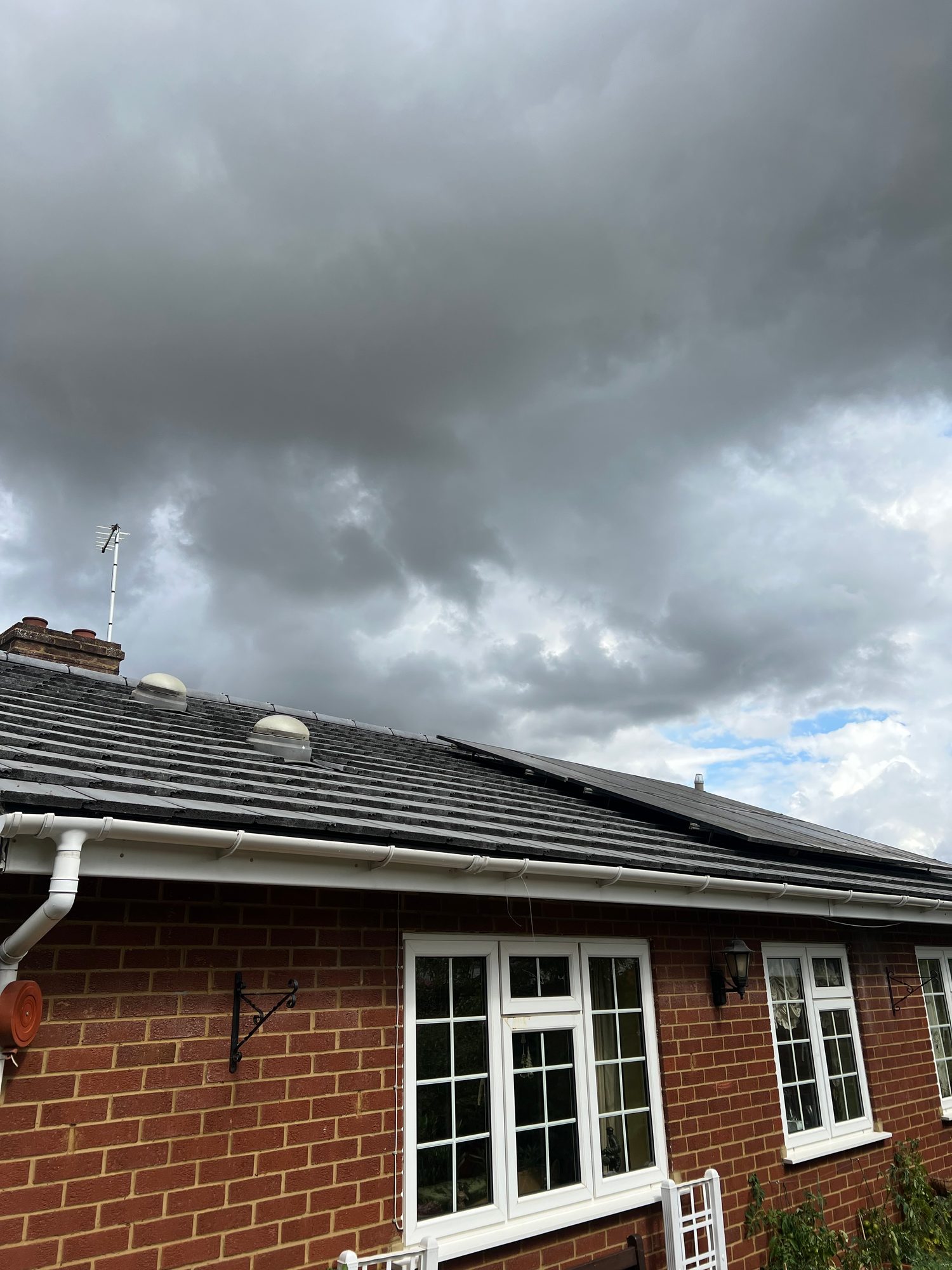 Completed roof replacement showing the finished roof covering, reinstated solar panels, roof vents and guttering