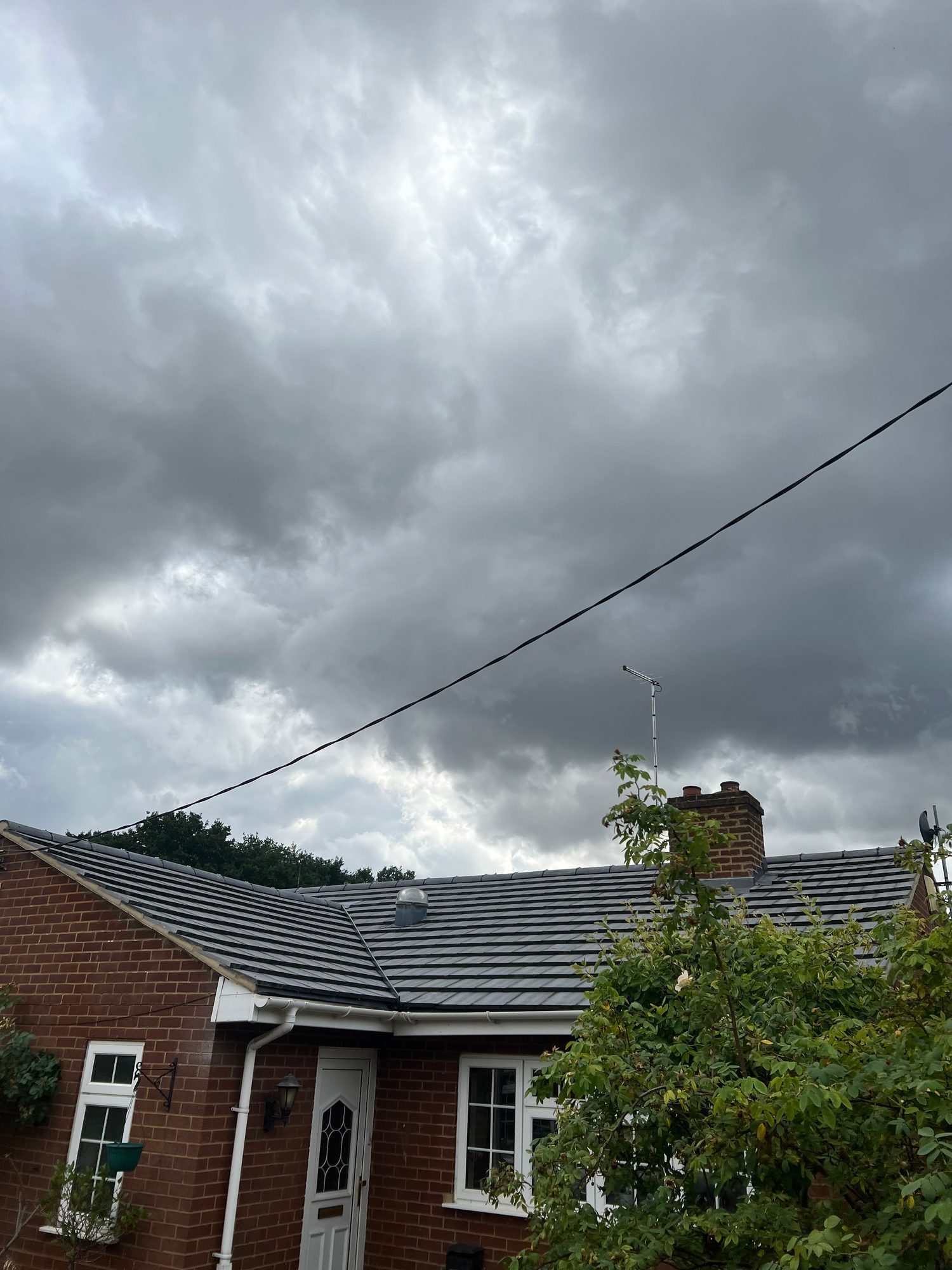 Finished roof replacement showing the new roof covering, roof vent, chimney, guttering and surrounding brickwork