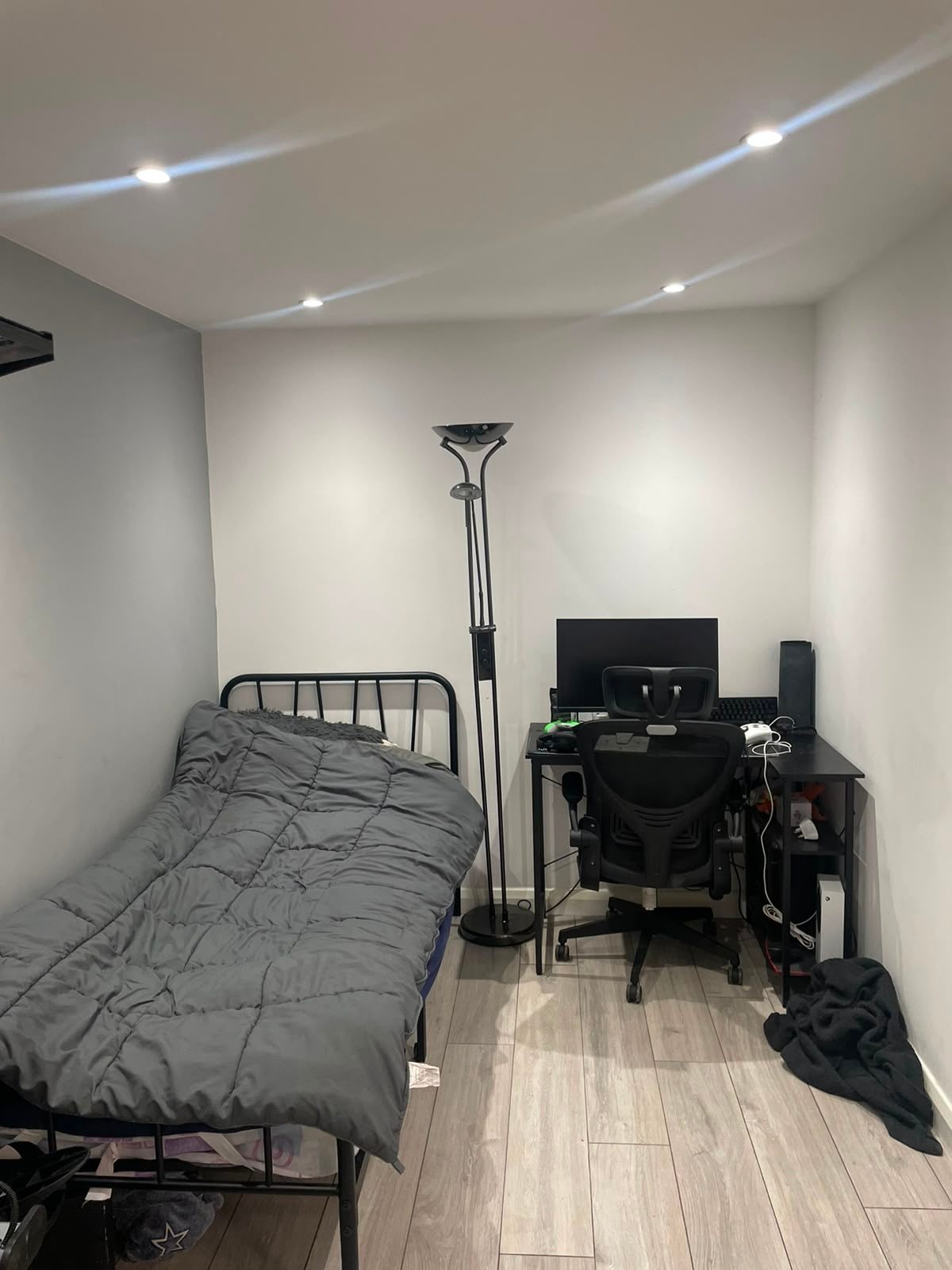 Refurbished room with grey wood-effect flooring, painted white and grey walls and recessed ceiling lights