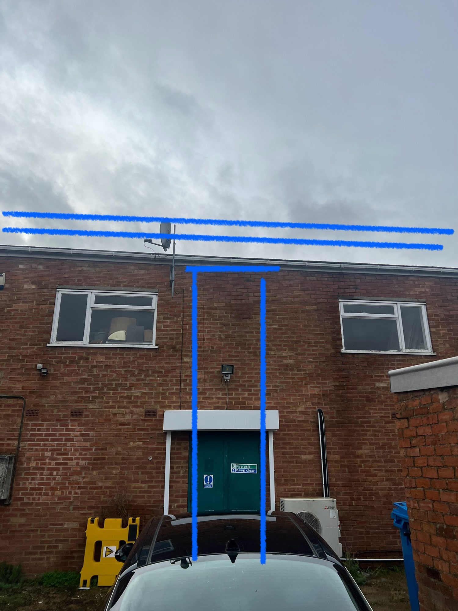 Before - The rear brick elevation showing the existing doorway, windows and marked area for the proposed works