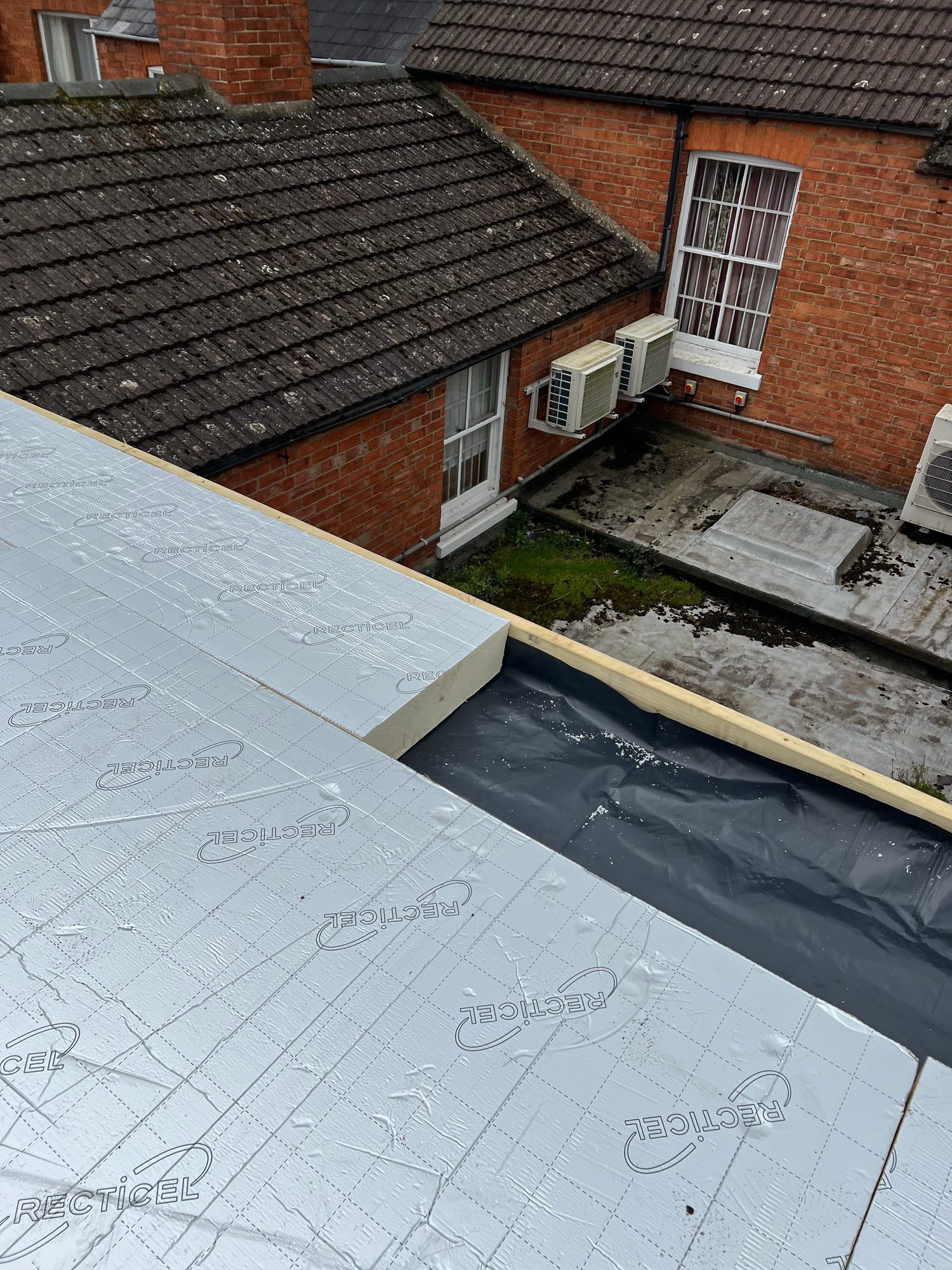 During - The flat roof during installation with rigid insulation boards being fitted over the roof structure