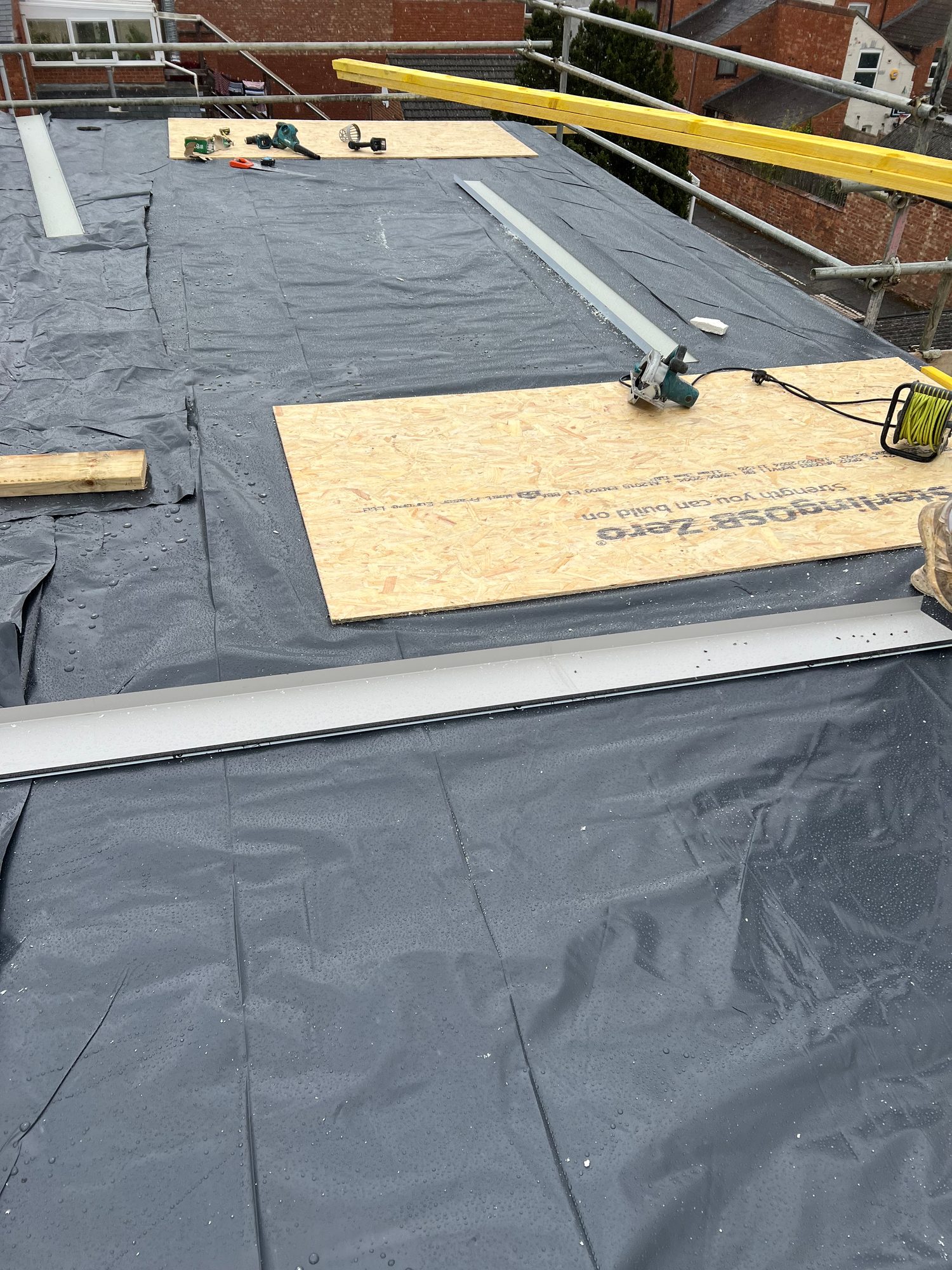 During - The flat roof during installation with the membrane laid and roof detailing in progress