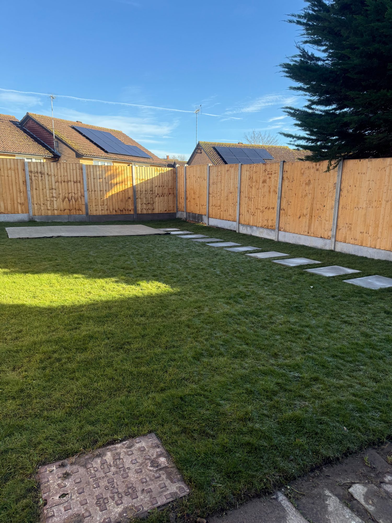 Completed rear garden with fresh turf, new timber fencing, concrete stepping stones and a rectangular base